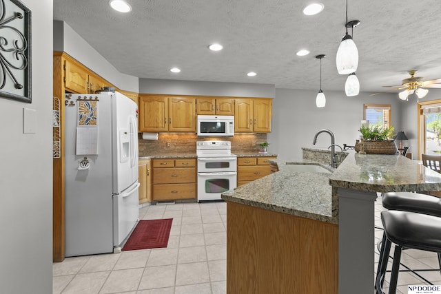 S-1196 N Lake Shore Dr, Fremont, NE 68025 - kitchen featuring white appliances, a sink, light tile patterned floors, a kitchen breakfast bar, and decorative backsplash