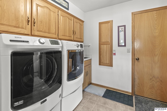 S-1196 N Lake Shore Dr, Fremont, NE 68025 - washroom featuring washing machine and dryer, cabinet space, light tile patterned floors, and baseboards