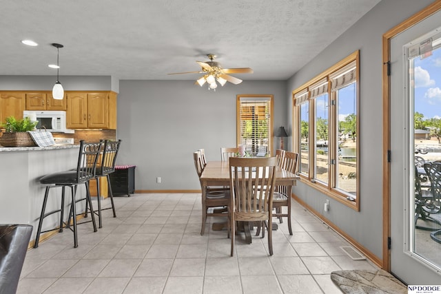S-1196 N Lake Shore Dr, Fremont, NE 68025 - dining space with a ceiling fan, baseboards, light tile patterned flooring, recessed lighting, and a textured ceiling
