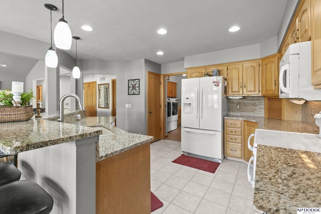 S-1196 N Lake Shore Dr, Fremont, NE 68025 - kitchen with white appliances, decorative backsplash, a kitchen bar, a sink, and light stone countertops