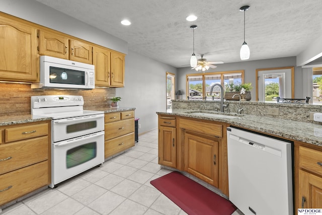 S-1196 N Lake Shore Dr, Fremont, NE 68025 - kitchen featuring white appliances, a sink, decorative backsplash, hanging light fixtures, and light stone countertops