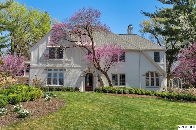 423 Fairacres Rd, Omaha, NE 68132 - tudor-style house featuring a front yard, a chimney, and brick siding