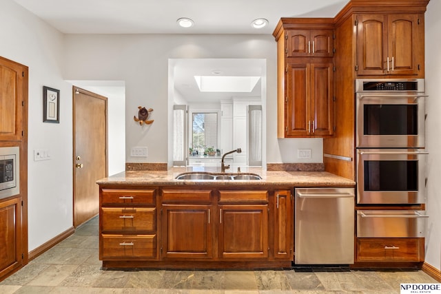 423 Fairacres Rd, Omaha, NE 68132 - kitchen featuring a sink, a warming drawer, appliances with stainless steel finishes, a skylight, and baseboards