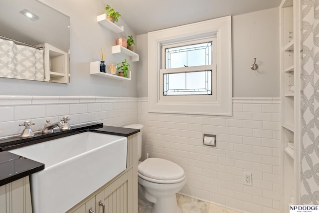 423 Fairacres Rd, Omaha, NE 68132 - bathroom featuring tile walls, vanity, toilet, and a wainscoted wall