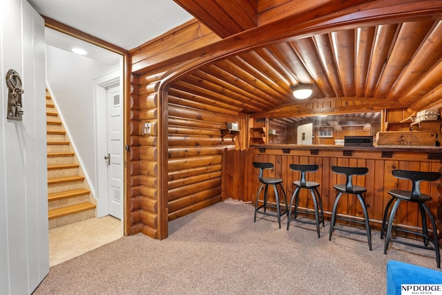 423 Fairacres Rd, Omaha, NE 68132 - bar featuring log walls, carpet flooring, stairway, and vaulted ceiling