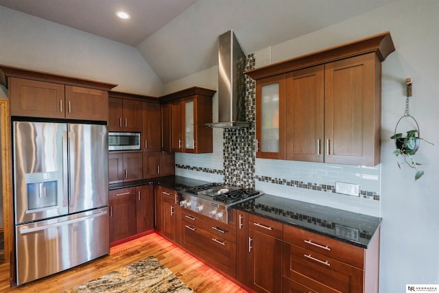 10955 N 58th Plz, Omaha, NE 68152 - kitchen with appliances with stainless steel finishes, wall chimney exhaust hood, light wood-style floors, dark stone counters, and tasteful backsplash