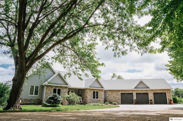 10955 N 58th Plz, Omaha, NE 68152 - view of front of house featuring stone siding, a garage, driveway, and a front lawn