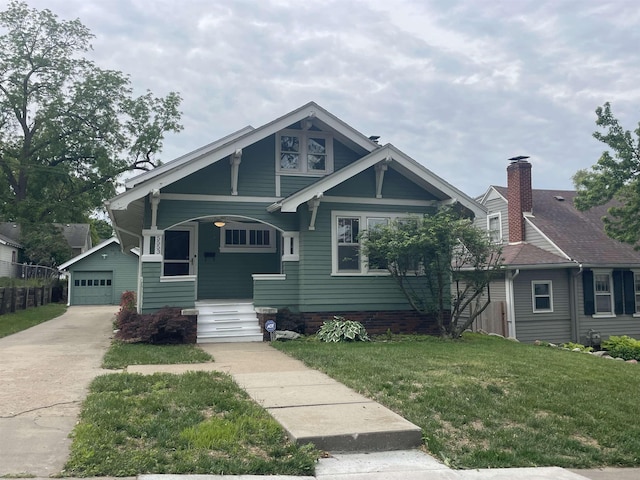 5553 Mayberry St, Omaha, NE 68106 - view of front of house featuring a front lawn, driveway, a detached garage, and a porch