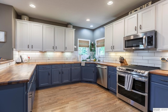 15210 Craig Cir, Bennington, NE 68007 - kitchen featuring wooden counters, blue cabinetry, appliances with stainless steel finishes, white cabinets, and recessed lighting