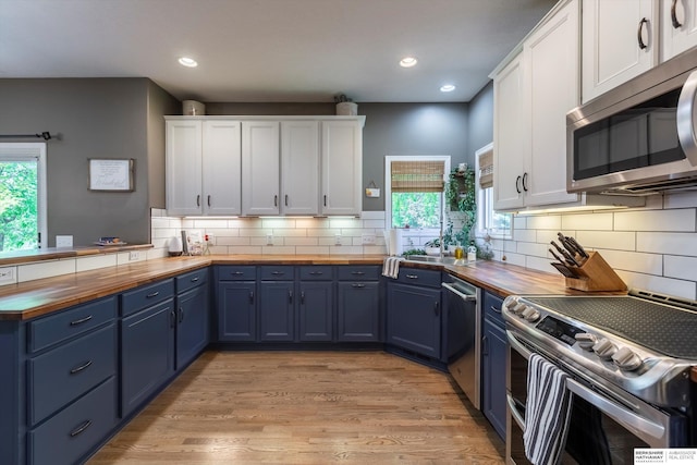 15210 Craig Cir, Bennington, NE 68007 - kitchen featuring butcher block countertops, stainless steel appliances, blue cabinets, white cabinets, and recessed lighting