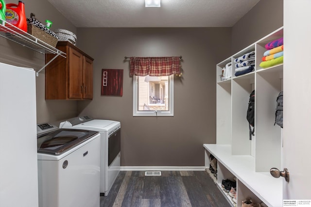 15210 Craig Cir, Bennington, NE 68007 - laundry room featuring dark wood-style flooring, washing machine and dryer, cabinet space, baseboards, and a textured ceiling