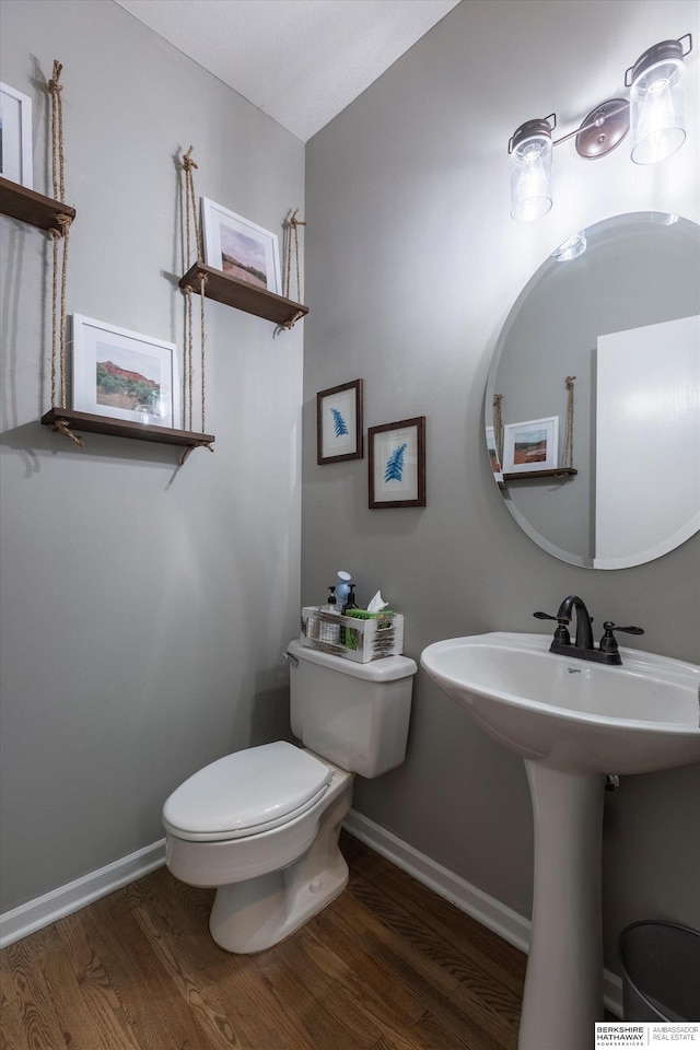 15210 Craig Cir, Bennington, NE 68007 - half bath with toilet, wood finished floors, baseboards, and a sink