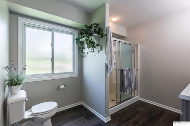 15210 Craig Cir, Bennington, NE 68007 - full bath with wood finished floors, toilet, a shower stall, baseboards, and a textured ceiling