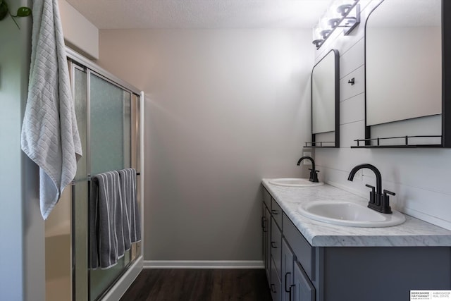 15210 Craig Cir, Bennington, NE 68007 - bathroom with wood finished floors, a shower stall, double vanity, and baseboards