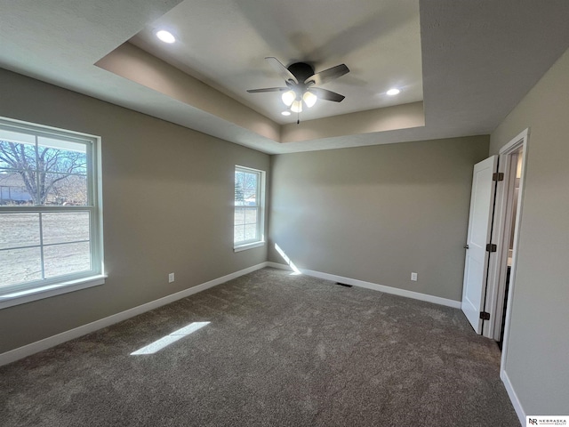 117 N Edna St, Valentine, NE 69201 - spare room featuring a tray ceiling, plenty of natural light, ceiling fan, dark carpet, and recessed lighting