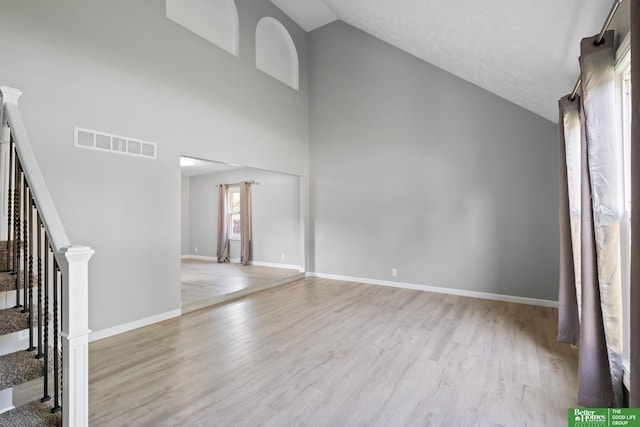 3501 Leawood Dr, Bellevue, NE 68123 - unfurnished living room featuring wood finished floors, high vaulted ceiling, and baseboards