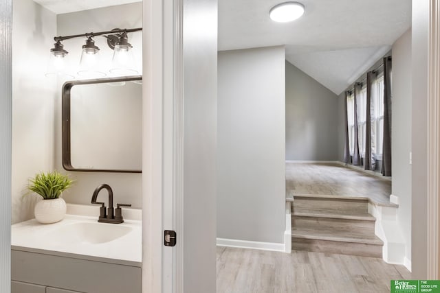 3501 Leawood Dr, Bellevue, NE 68123 - bathroom with lofted ceiling, vanity, wood finished floors, and baseboards