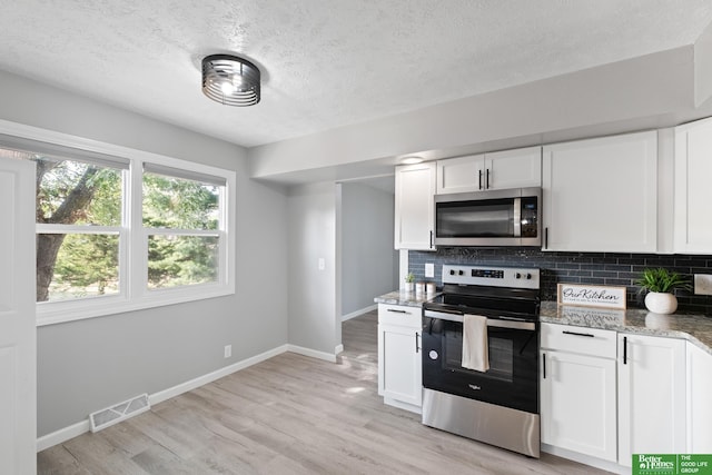 3501 Leawood Dr, Bellevue, NE 68123 - kitchen featuring stainless steel appliances, tasteful backsplash, baseboards, light stone countertops, and a textured ceiling