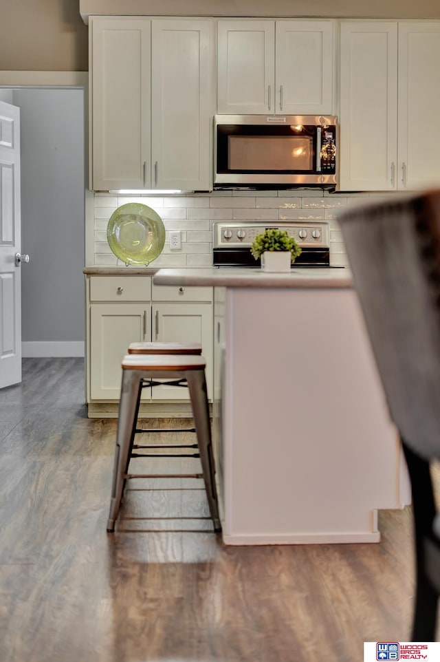 7627 S 38th St, Lincoln, NE 68516 - kitchen with stainless steel microwave, electric stove, light countertops, decorative backsplash, and white cabinets
