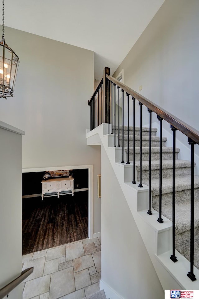 7627 S 38th St, Lincoln, NE 68516 - stairs with a chandelier, baseboards, a high ceiling, and wood finished floors