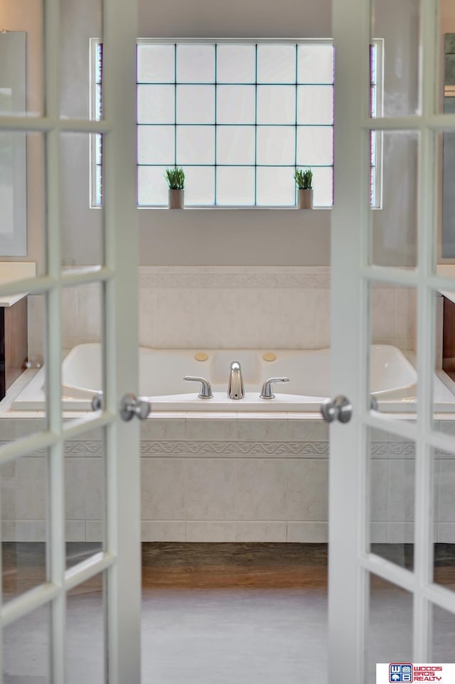 7627 S 38th St, Lincoln, NE 68516 - bathroom featuring wood finished floors, a garden tub, and french doors