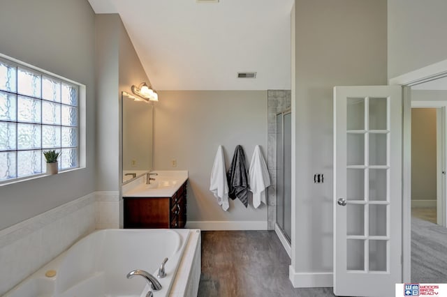 7627 S 38th St, Lincoln, NE 68516 - bathroom with vanity, a bath, a shower stall, baseboards, and lofted ceiling