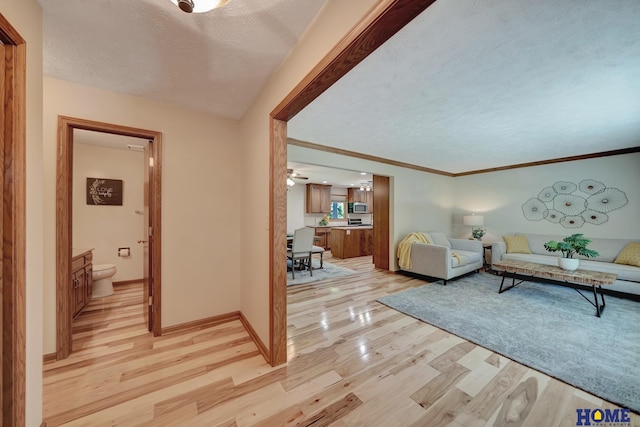 4801 S 72nd St, Lincoln, NE 68516 - living area with a textured ceiling, light wood-style floors, a ceiling fan, baseboards, and crown molding