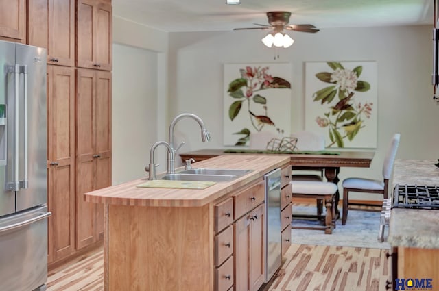 4801 S 72nd St, Lincoln, NE 68516 - kitchen with stainless steel fridge, wooden counters, a sink, a center island with sink, and a ceiling fan
