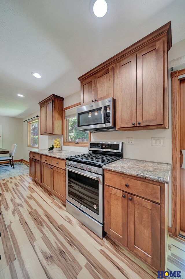 4801 S 72nd St, Lincoln, NE 68516 - kitchen with appliances with stainless steel finishes, light wood-style floors, recessed lighting, brown cabinetry, and baseboards
