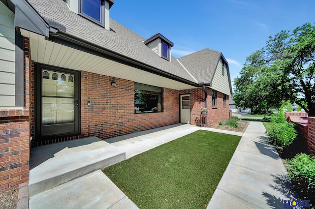 4801 S 72nd St, Lincoln, NE 68516 - property entrance with brick siding, a shingled roof, and a lawn