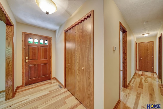 4801 S 72nd St, Lincoln, NE 68516 - foyer featuring light wood-type flooring, a textured ceiling, and baseboards