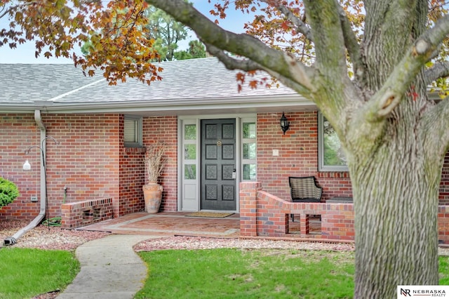6844 Laurent Cir, Lincoln, NE 68526 - doorway to property featuring brick siding and a shingled roof