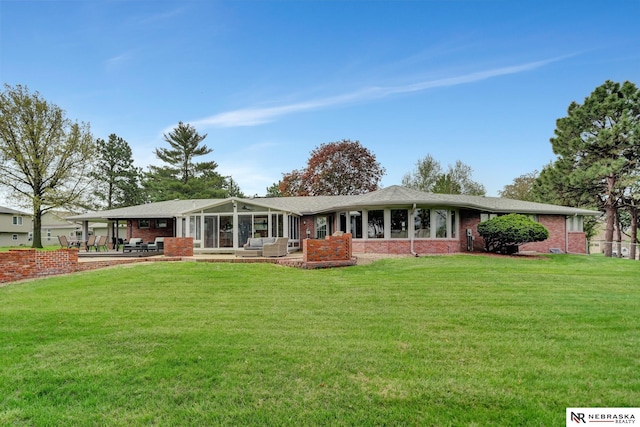 6844 Laurent Cir, Lincoln, NE 68526 - rear view of house with brick siding, a sunroom, a lawn, and a patio area