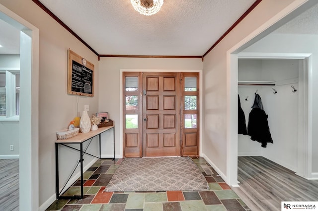 6844 Laurent Cir, Lincoln, NE 68526 - foyer entrance featuring ornamental molding, a textured ceiling, baseboards, and dark stone finish floors