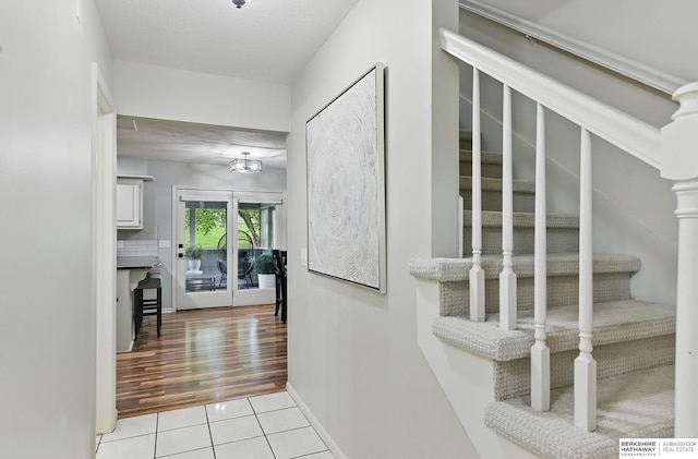 1725 N 162nd St, Omaha, NE 68118 - corridor with light tile patterned floors, a chandelier, baseboards, and stairs