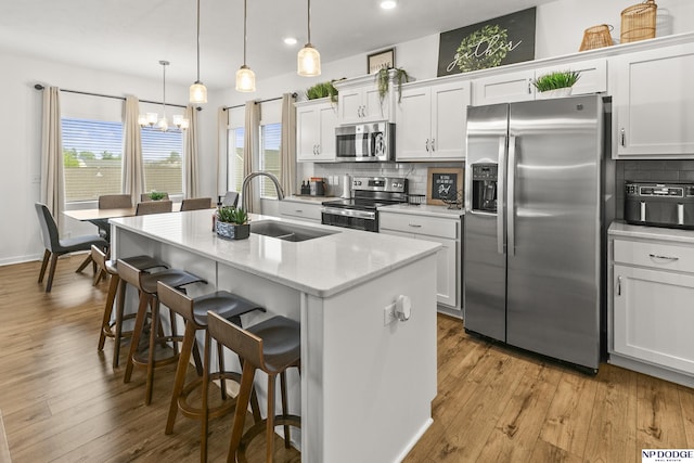 7717 N 108th St, Omaha, NE 68142 - kitchen with appliances with stainless steel finishes, a sink, a chandelier, backsplash, and recessed lighting