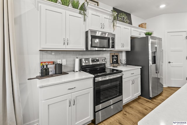 7717 N 108th St, Omaha, NE 68142 - kitchen with stainless steel appliances, decorative backsplash, white cabinets, light wood finished floors, and recessed lighting