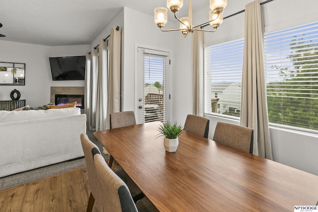 7717 N 108th St, Omaha, NE 68142 - dining space with a chandelier, a glass covered fireplace, and wood finished floors
