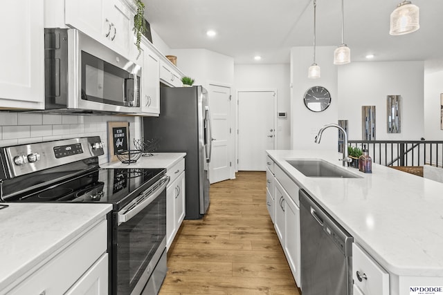 7717 N 108th St, Omaha, NE 68142 - kitchen featuring stainless steel appliances, a sink, light wood-style floors, white cabinets, and recessed lighting
