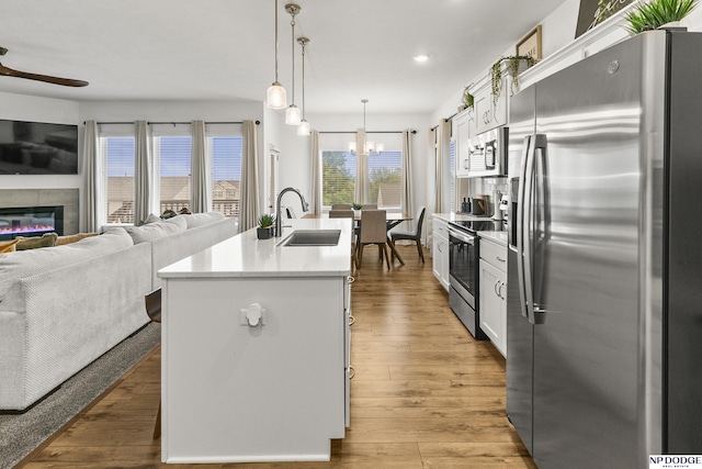 7717 N 108th St, Omaha, NE 68142 - kitchen featuring appliances with stainless steel finishes, a sink, open floor plan, a kitchen island with sink, and a ceiling fan