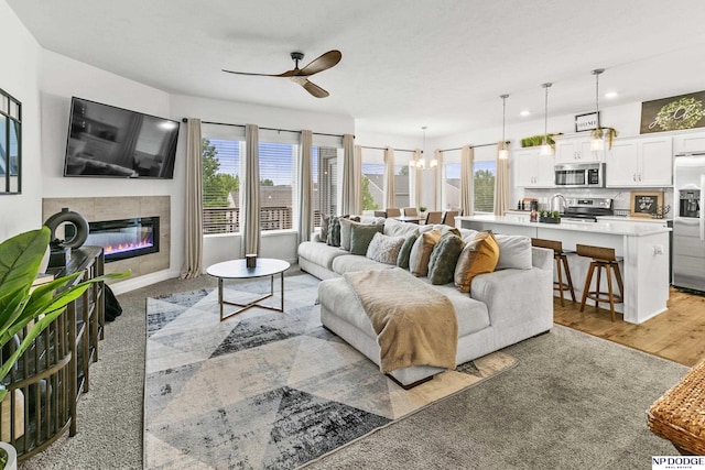 7717 N 108th St, Omaha, NE 68142 - living area featuring ceiling fan, healthy amount of natural light, a glass covered fireplace, and a chandelier