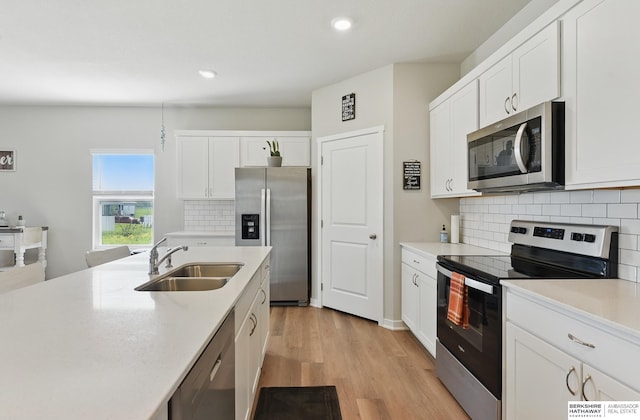6312 Centennial Rd, Papillion, NE 68157 - kitchen with stainless steel appliances, a sink, white cabinetry, recessed lighting, and light wood finished floors