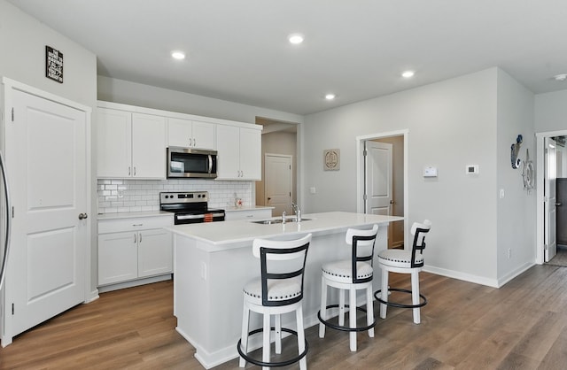 6312 Centennial Rd, Papillion, NE 68157 - kitchen featuring stainless steel appliances, an island with sink, tasteful backsplash, white cabinetry, and recessed lighting