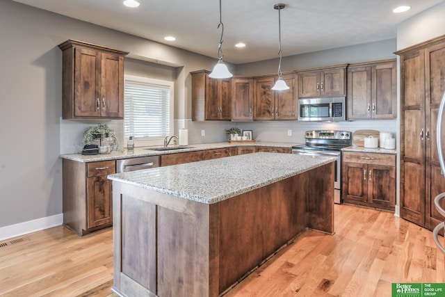10311 S 124th St, Papillion, NE 68046 - kitchen featuring stainless steel appliances, a sink, light wood finished floors, a center island, and tasteful backsplash