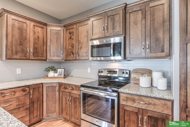 10311 S 124th St, Papillion, NE 68046 - kitchen with stainless steel appliances, decorative backsplash, light wood finished floors, and light stone counters