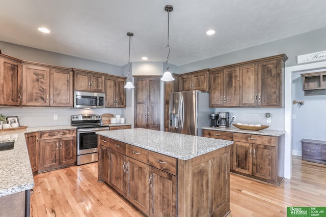 10311 S 124th St, Papillion, NE 68046 - kitchen with stainless steel appliances, a kitchen island, light wood-style flooring, decorative backsplash, and decorative light fixtures