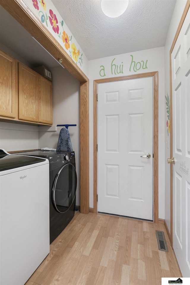 9521 N 140th St, Waverly, NE 68462 - laundry room with cabinet space, independent washer and dryer, light wood finished floors, a textured ceiling, and baseboards