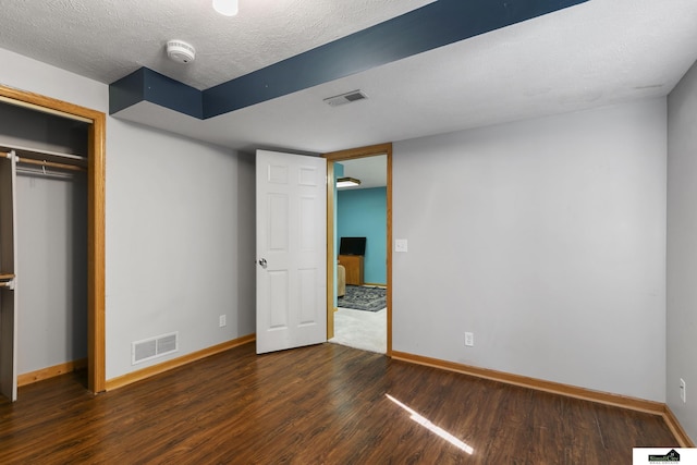9521 N 140th St, Waverly, NE 68462 - unfurnished bedroom with dark wood-style floors, baseboards, a closet, and a textured ceiling
