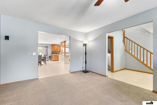 9521 N 140th St, Waverly, NE 68462 - unfurnished living room featuring light carpet, a ceiling fan, baseboards, stairs, and light tile patterned floors