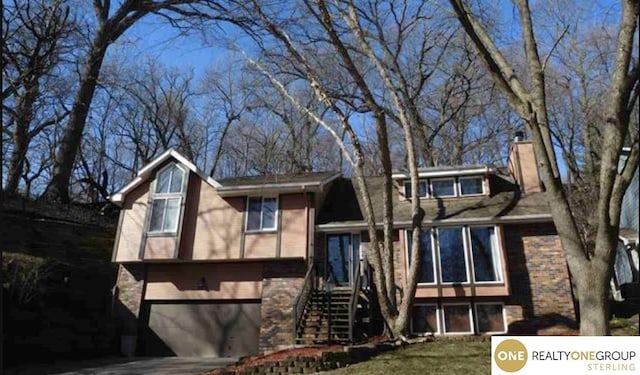 826 Hidden Hills Dr, Bellevue, NE 68005 - view of front of property with a garage, a chimney, stairway, and driveway